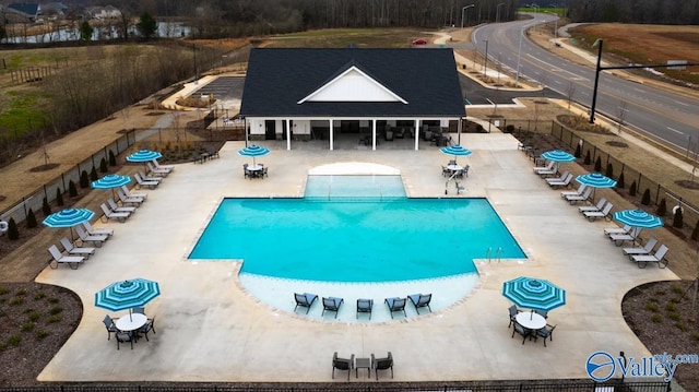 community pool featuring fence, a patio, and outdoor dining area
