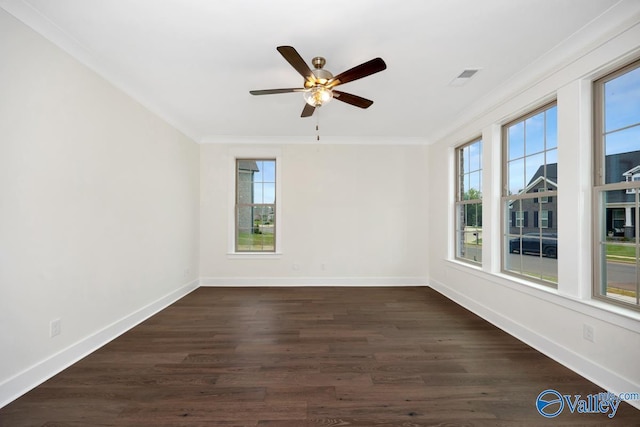 empty room featuring crown molding, plenty of natural light, baseboards, and dark wood-style floors