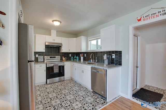 1608 Humes Ave, Huntsville, AL 35801 - kitchen with white cabinetry, under cabinet range hood, a sink, appliances with stainless steel finishes, and backsplash