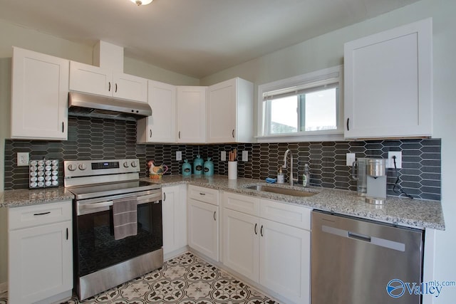 1608 Humes Ave, Huntsville, AL 35801 - kitchen with under cabinet range hood, white cabinets, tasteful backsplash, a sink, and appliances with stainless steel finishes