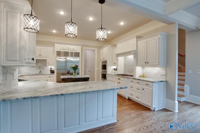 kitchen with white cabinets, stainless steel appliances, backsplash, and light wood-type flooring