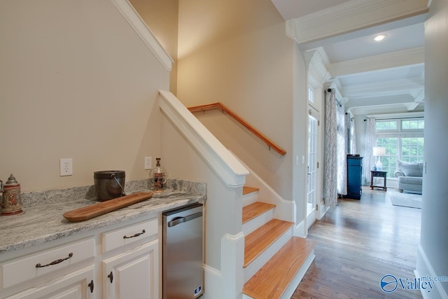 bar with white cabinetry, beamed ceiling, light stone countertops, and light wood-type flooring