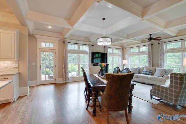 dining room featuring coffered ceiling, crown molding, and light wood-type flooring