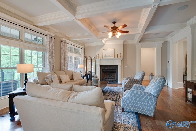 living room featuring coffered ceiling, dark hardwood / wood-style flooring, beamed ceiling, a premium fireplace, and decorative columns