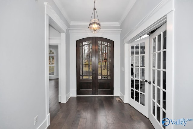 entrance foyer featuring french doors, dark wood-type flooring, and ornamental molding