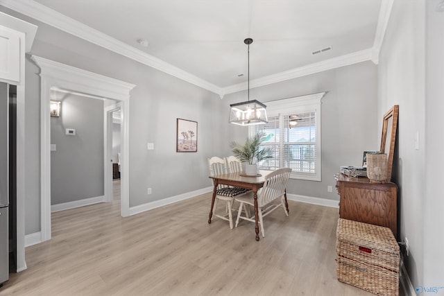 17067 Stonegate Dr, Athens, AL 35613 - dining space with light wood-type flooring, baseboards, visible vents, an inviting chandelier, and crown molding