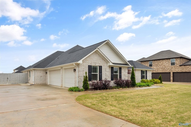 17067 Stonegate Dr, Athens, AL 35613 - view of front facade featuring fence, a front lawn, concrete driveway, brick siding, and a garage