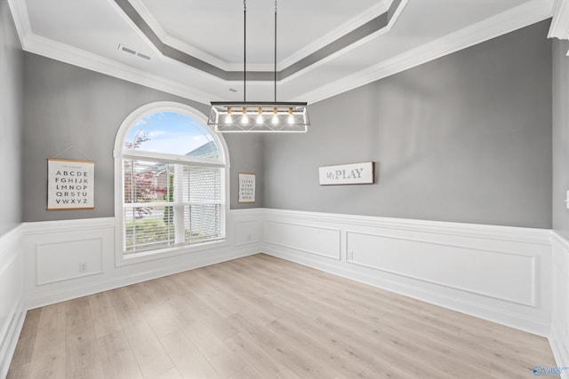 17067 Stonegate Dr, Athens, AL 35613 - unfurnished dining area with a wainscoted wall, a tray ceiling, light wood-style floors, and crown molding
