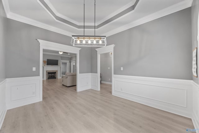17067 Stonegate Dr, Athens, AL 35613 - unfurnished dining area with a tray ceiling, wood finished floors, ornamental molding, wainscoting, and a fireplace
