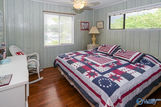 bedroom with a ceiling fan, multiple windows, wood finished floors, and ornamental molding