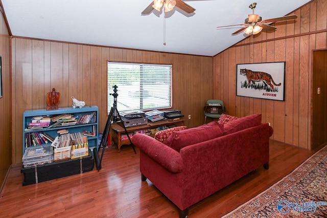 living room featuring wood walls, ceiling fan, lofted ceiling, crown molding, and hardwood / wood-style flooring