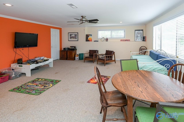 dining room with carpet flooring, visible vents, a wealth of natural light, and ornamental molding