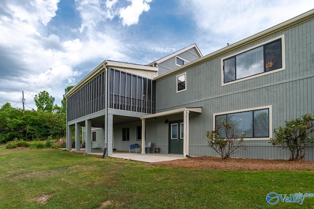 rear view of property with a patio area, a yard, and a sunroom