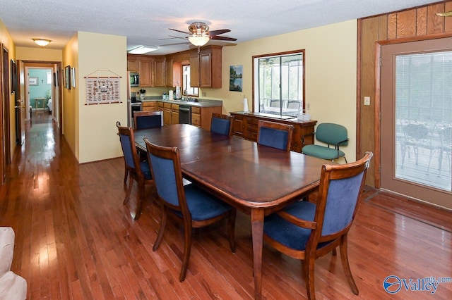 dining room with a textured ceiling, wood finished floors, and ceiling fan