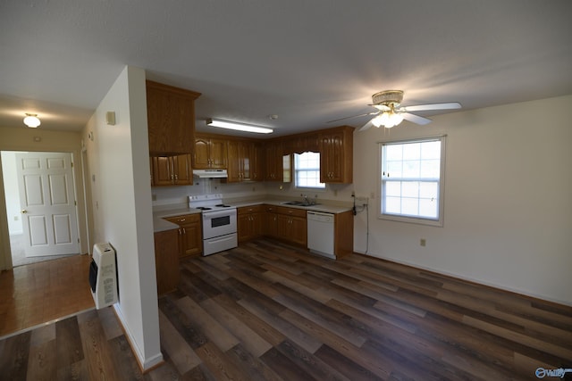 kitchen featuring dark wood-type flooring, sink, heating unit, ceiling fan, and white appliances