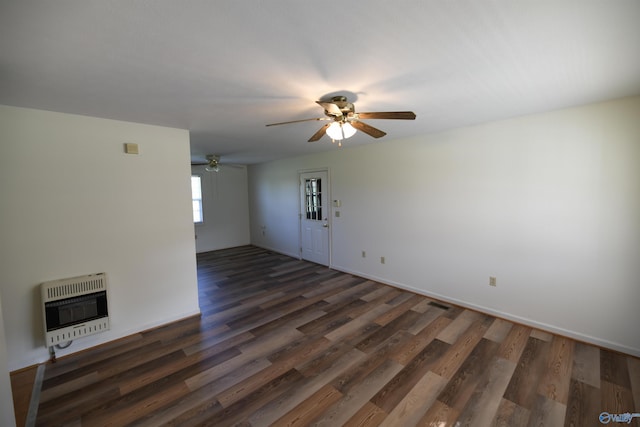 unfurnished room featuring dark wood-type flooring, ceiling fan, and heating unit