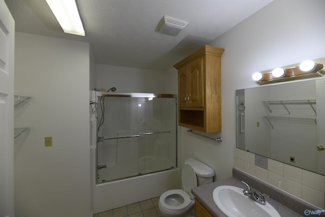 full bathroom featuring backsplash, enclosed tub / shower combo, vanity, toilet, and tile patterned floors