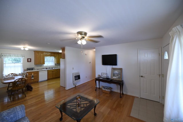 living room with ceiling fan, sink, heating unit, and light hardwood / wood-style floors