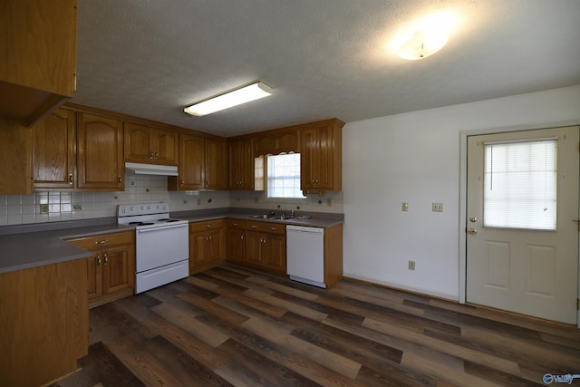 kitchen with dark wood-type flooring, white appliances, sink, and tasteful backsplash