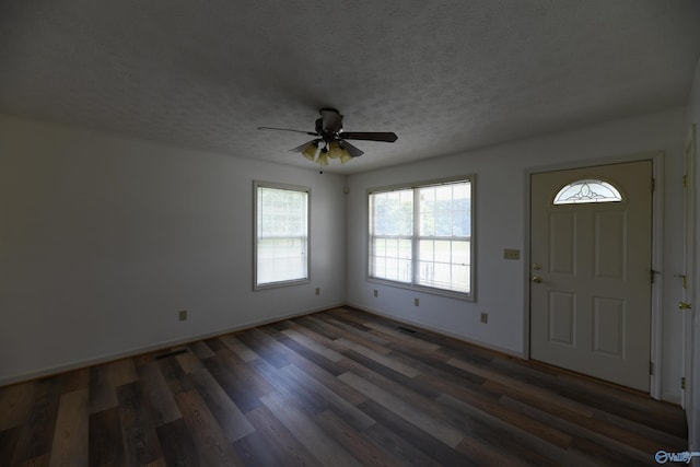 foyer featuring ceiling fan, dark wood-type flooring, and a textured ceiling