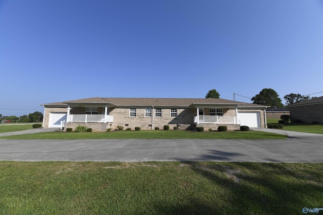 single story home with a garage, a front yard, and covered porch