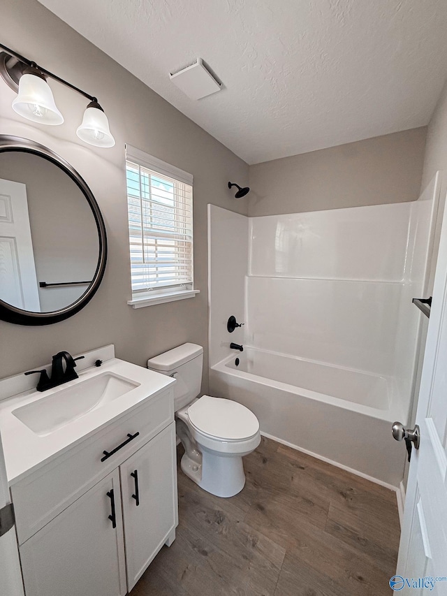 918 Wilson Ave, Gadsden, AL 35903 - bathroom with wood finished floors, vanity, a textured ceiling, bathing tub / shower combination, and toilet