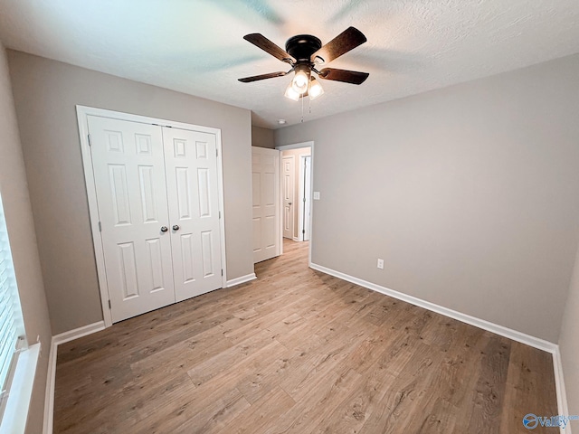 918 Wilson Ave, Gadsden, AL 35903 - unfurnished bedroom with light wood-style flooring, baseboards, a closet, and a ceiling fan