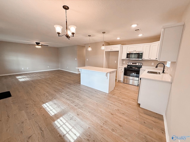 918 Wilson Ave, Gadsden, AL 35903 - kitchen with stainless steel appliances, a sink, ceiling fan, white cabinetry, and hanging light fixtures