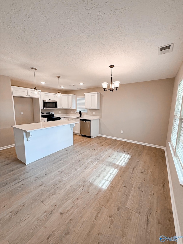 918 Wilson Ave, Gadsden, AL 35903 - kitchen featuring appliances with stainless steel finishes, a sink, a chandelier, a textured ceiling, and baseboards