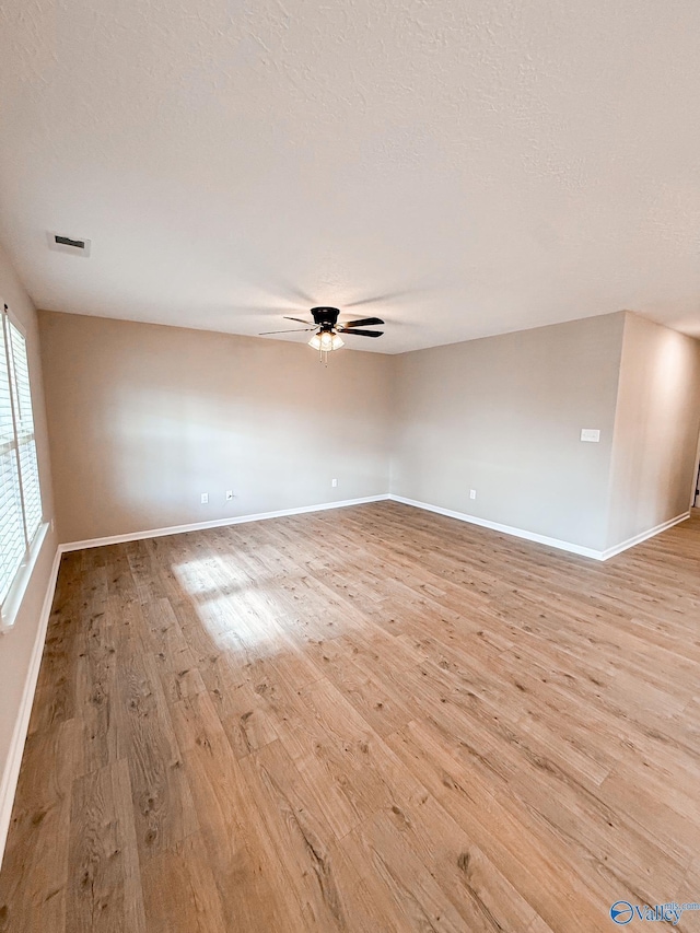 918 Wilson Ave, Gadsden, AL 35903 - spare room featuring light wood-style flooring, a ceiling fan, baseboards, and a textured ceiling