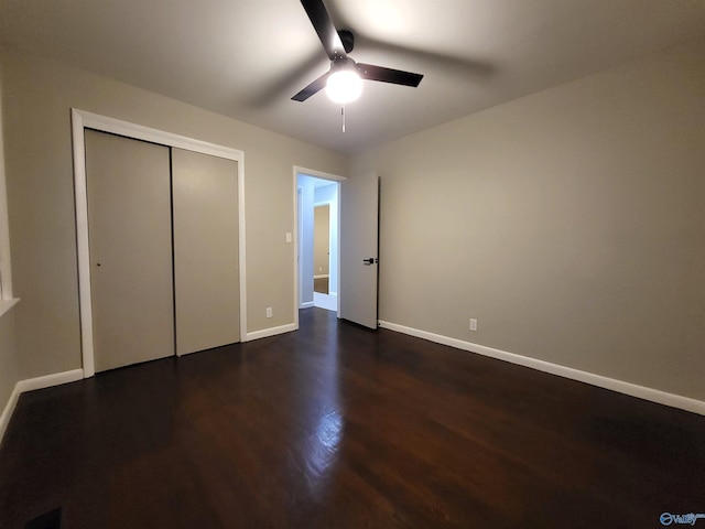 unfurnished bedroom featuring dark wood-type flooring, a closet, and ceiling fan