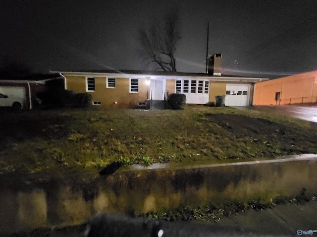 back house at night featuring a garage