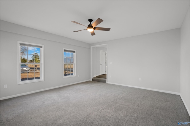 unfurnished room with ceiling fan and carpet