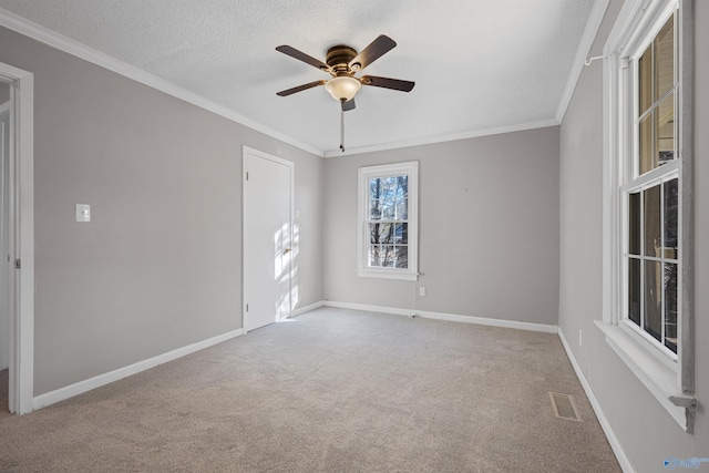 carpeted spare room featuring ornamental molding, a textured ceiling, and ceiling fan