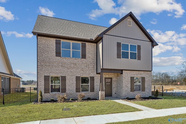 view of front of property featuring a front yard, fence, and brick siding