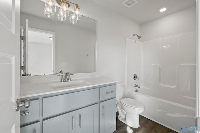 full bathroom with shower / washtub combination, hardwood / wood-style flooring, toilet, and vanity