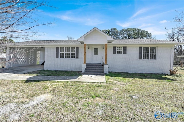 single story home featuring a carport, brick siding, and a front yard