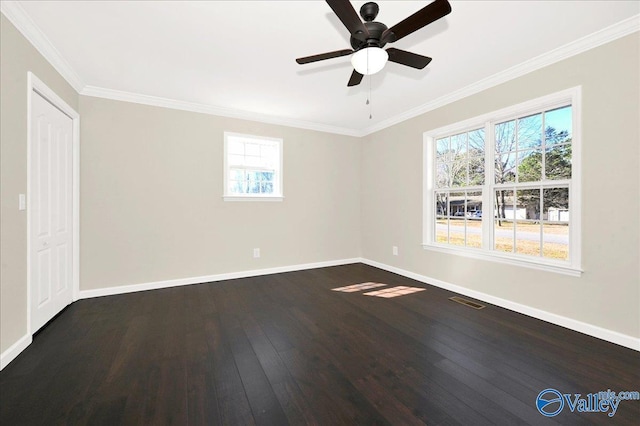 spare room featuring visible vents, baseboards, dark wood finished floors, and ornamental molding