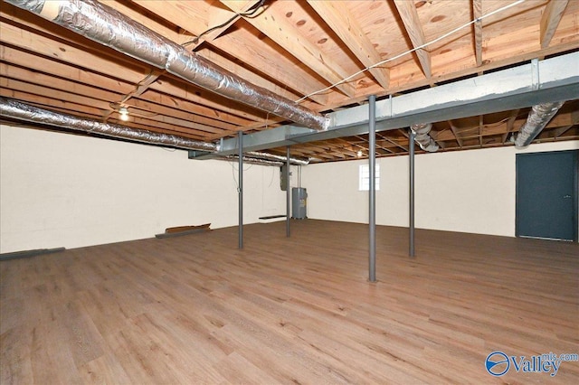 unfinished basement with water heater and wood finished floors