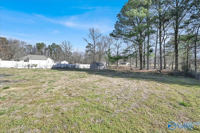 view of yard with a shed, fence, and an outdoor structure