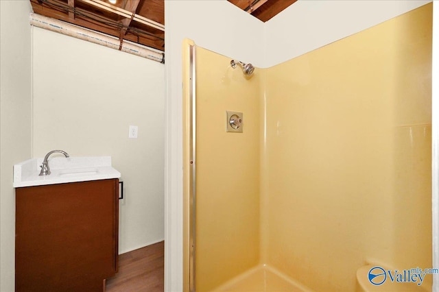 full bathroom featuring wood finished floors, vanity, and walk in shower