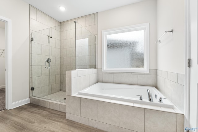 6228 Pisgah Dr NW, Huntsville, AL 35810 - full bathroom featuring a stall shower, a garden tub, wood finished floors, baseboards, and a spacious closet