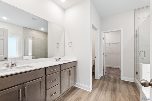 6228 Pisgah Dr NW, Huntsville, AL 35810 - bathroom featuring a shower stall, wood finished floors, double vanity, a spacious closet, and baseboards