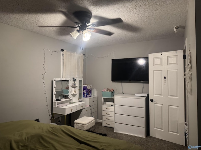 bedroom with ceiling fan, dark carpet, and a textured ceiling