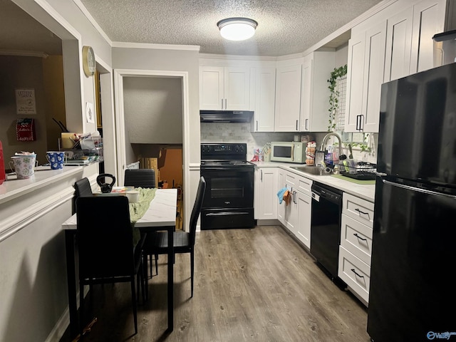 kitchen featuring black appliances, crown molding, sink, light hardwood / wood-style flooring, and white cabinetry