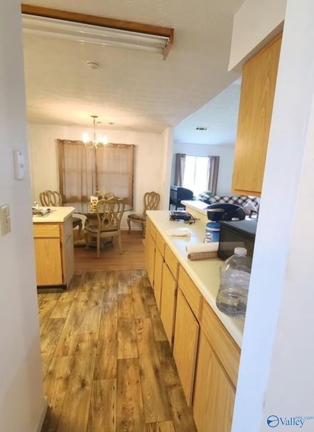 kitchen featuring hanging light fixtures, a notable chandelier, and light wood-type flooring