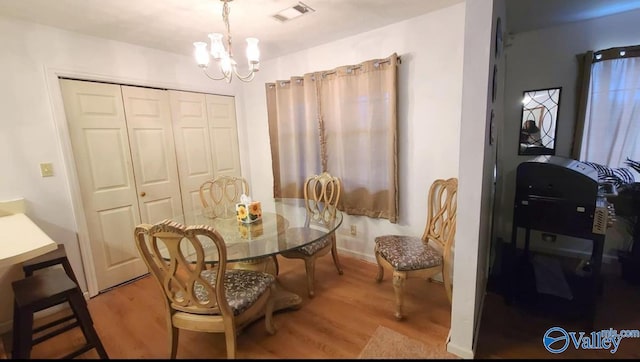 dining area featuring a notable chandelier and light hardwood / wood-style flooring