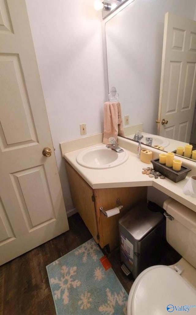 bathroom featuring wood-type flooring, vanity, and toilet