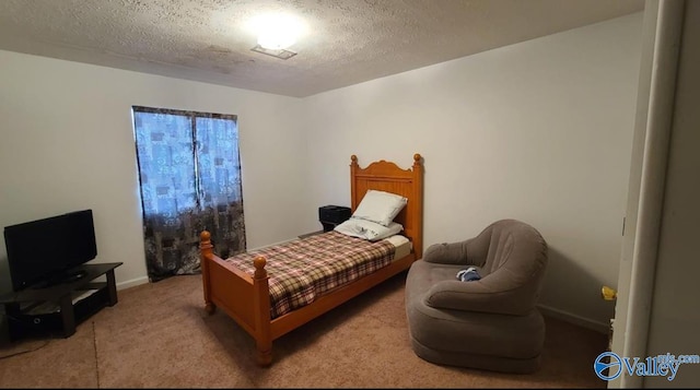 bedroom featuring light colored carpet and a textured ceiling