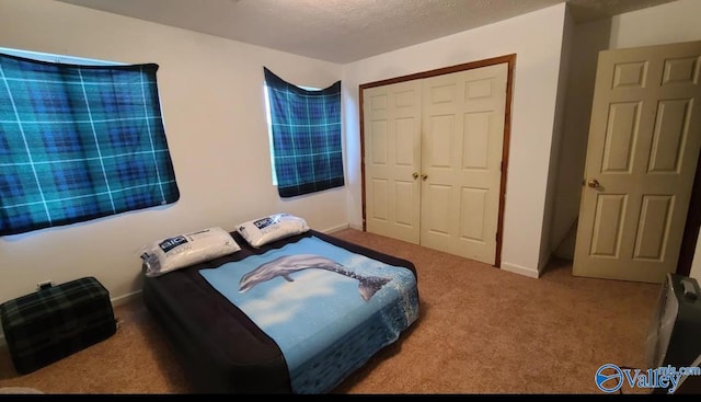 carpeted bedroom with a textured ceiling and a closet